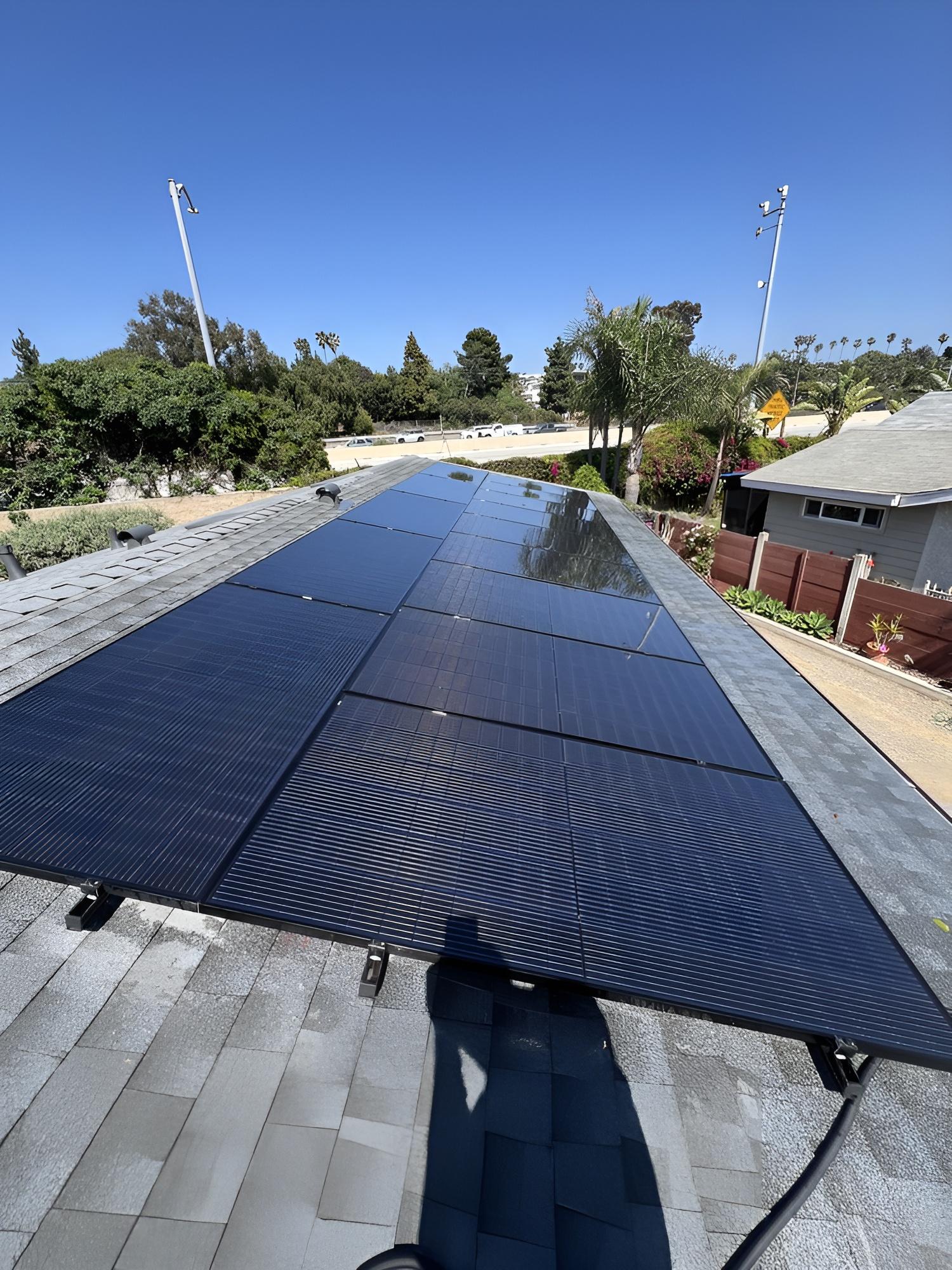 Clean solar panels on a roof with a clear blue sky (desktop)